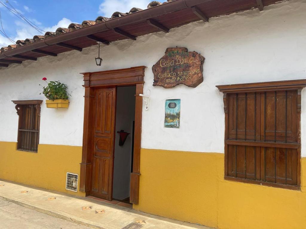 - un bâtiment avec une porte et un panneau dans l'établissement Casa Loma, à Zapatoca