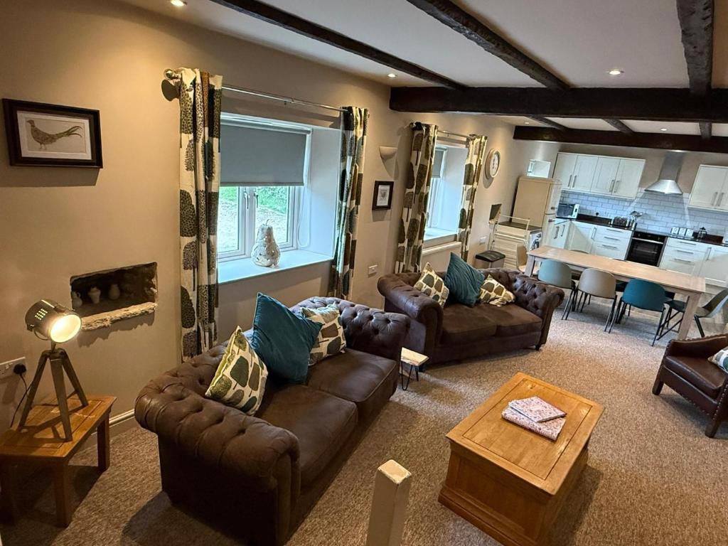 a living room with couches and a table and a kitchen at Tuckers Grave Inn - Historic Inn & Cider Pub in Norton Saint Philip