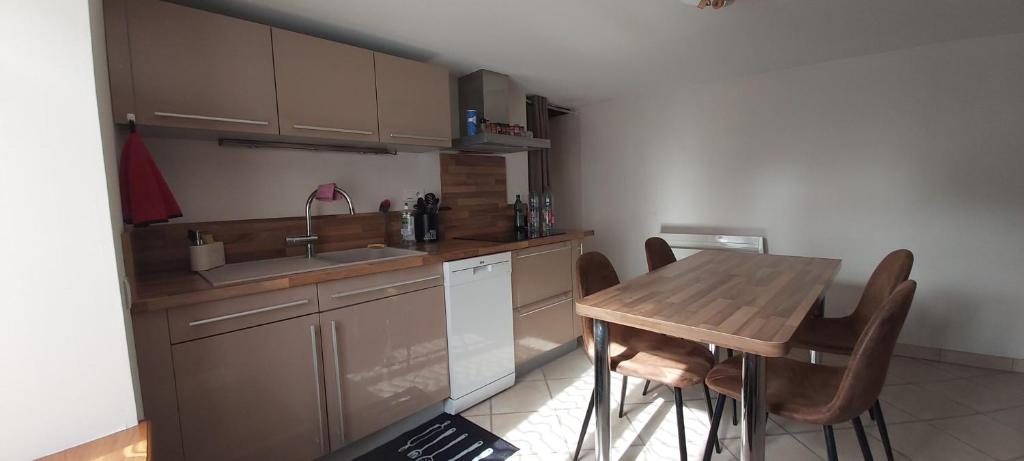 a kitchen with a wooden table and a sink at Maison cosy en pierre parking centre in Vittel