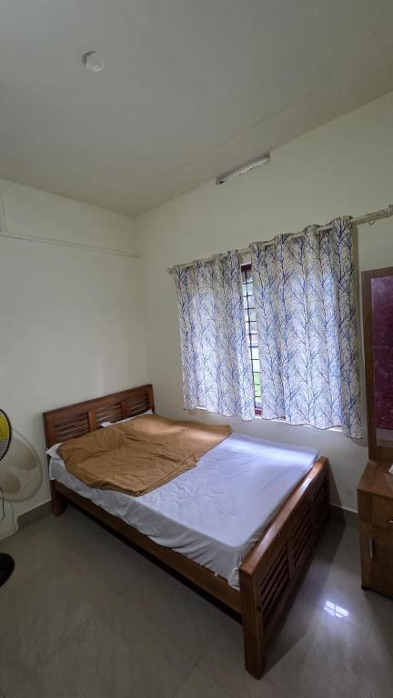 a bedroom with a large bed and a window at Valley Homestay in Devikolam