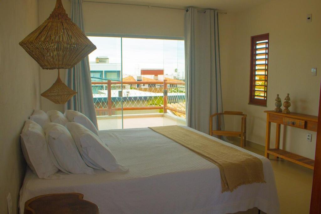 ein Schlafzimmer mit einem großen Bett und einem großen Fenster in der Unterkunft Villa Bella - São Miguel do Gostoso in Touros