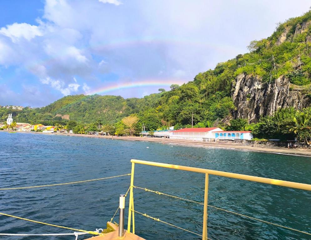 a boat in the water with a rainbow in the background at Kawaida - Hébergement insolite - Yaliyo in Saint-Pierre
