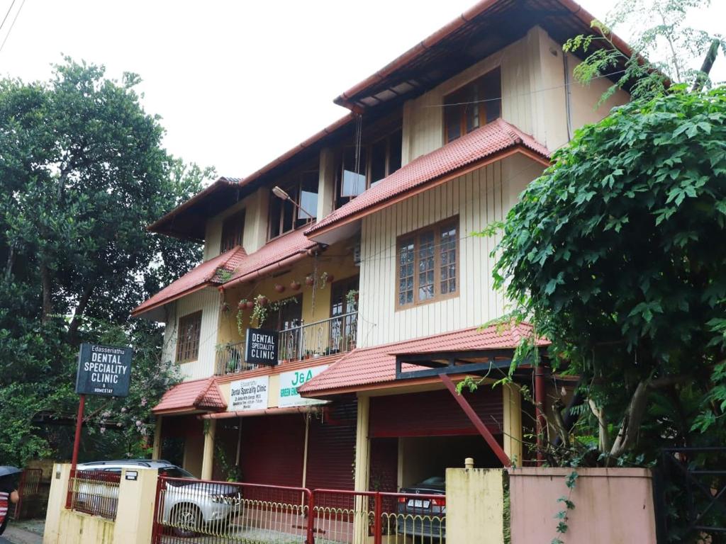 a building with a sign in front of it at Edasseriathu Homestays Tiruvalla in Tiruvalla