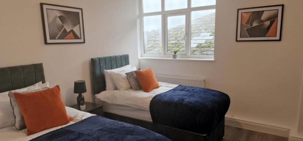 a bedroom with two beds and a window at The Felix Apartments - 2 Bedrooms - WIFI - FREE Parking in Flitwick