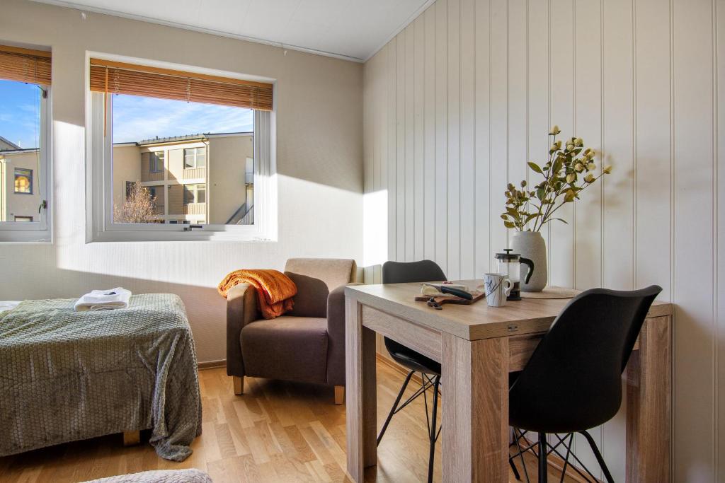 a living room with a table and a chair at Fjellheim Kurs- og Misjonssenter in Tromsø