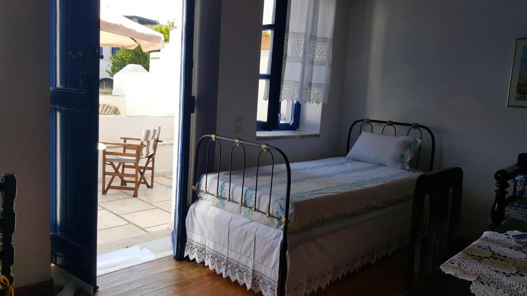 1 dormitorio con 1 cama y puerta que da a un patio en Ioanna's, en Pánormos