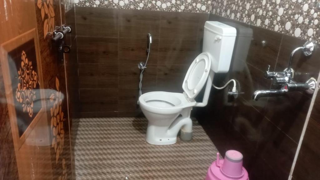 a bathroom with a white toilet in a stall at Shanti Nivas Homestay in Māvalli