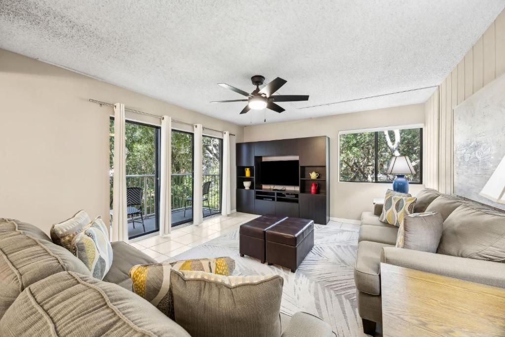 a living room with a couch and a ceiling fan at Pool View Beachwood Condo in Fernandina Beach