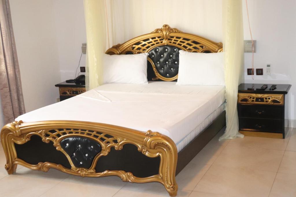 a bed with a wooden frame in a bedroom at Océan Voyages Mitsamihouli in Mitsamiouli