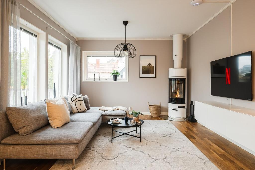 a living room with a couch and a tv at Guestly Homes - Spacious 2BR Executive Residence in Luleå
