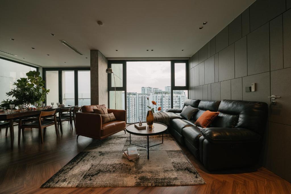 un salon avec un canapé en cuir et une table dans l'établissement Sunset view Sky Villa in Ecopark resort with private pool, à Cong Luận