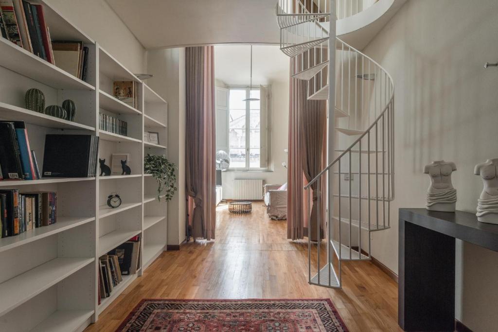 - un escalier en colimaçon dans un salon avec des étagères dans l'établissement Single House - Pisa, à Pise