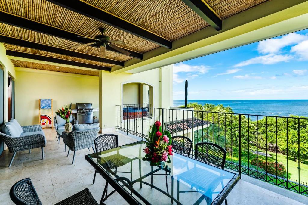 a patio with a glass table and chairs and the ocean at Beachfront Oceanview Private Jacuzzi & Full Ktcn in Tamarindo