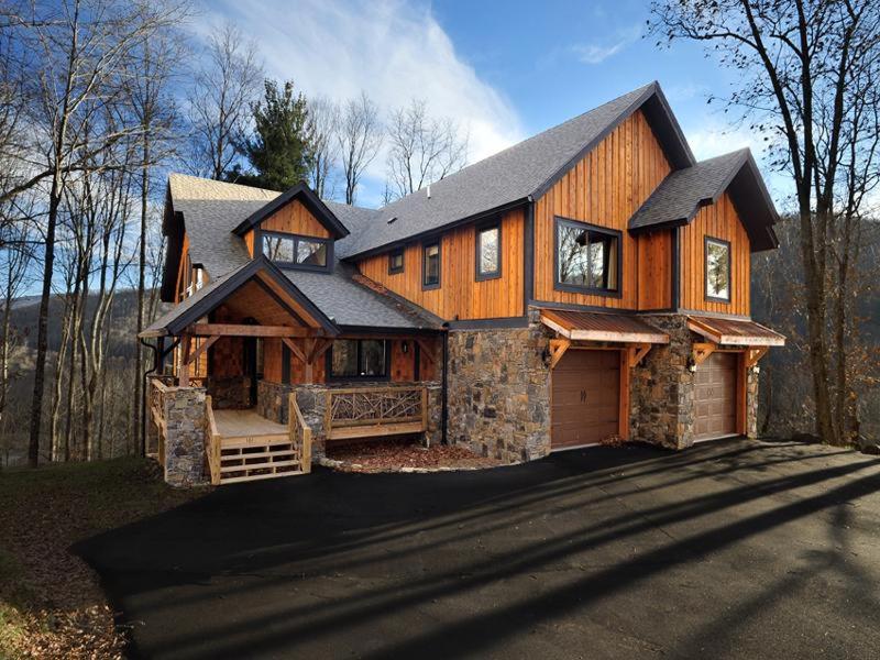 a large wooden house with a garage on a street at Cedar Rock Townhomes at Eagles Nest in Banner Elk