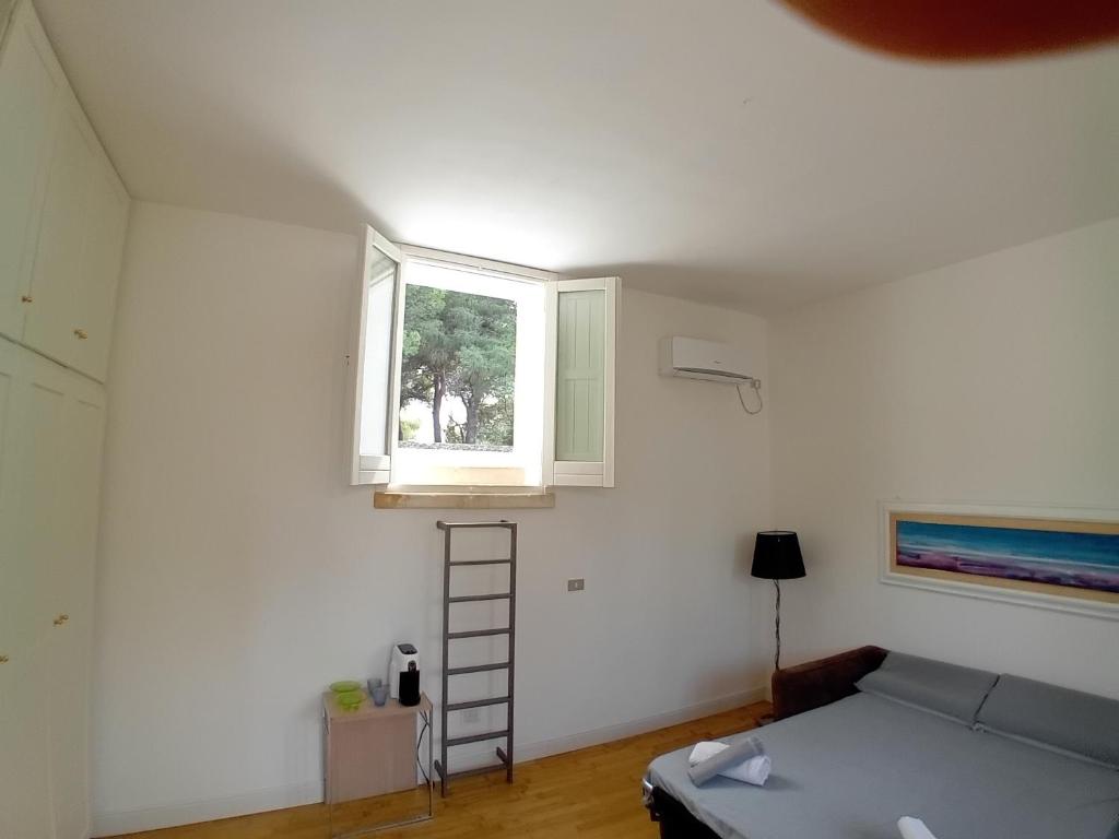 a room with a bed and a window and a ladder at Sud e Sole in Arnesano