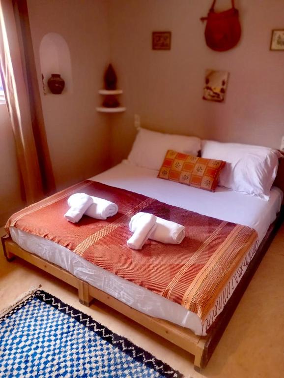 a bedroom with a bed with two towels on it at Dar INNÂ in Aït Benhaddou