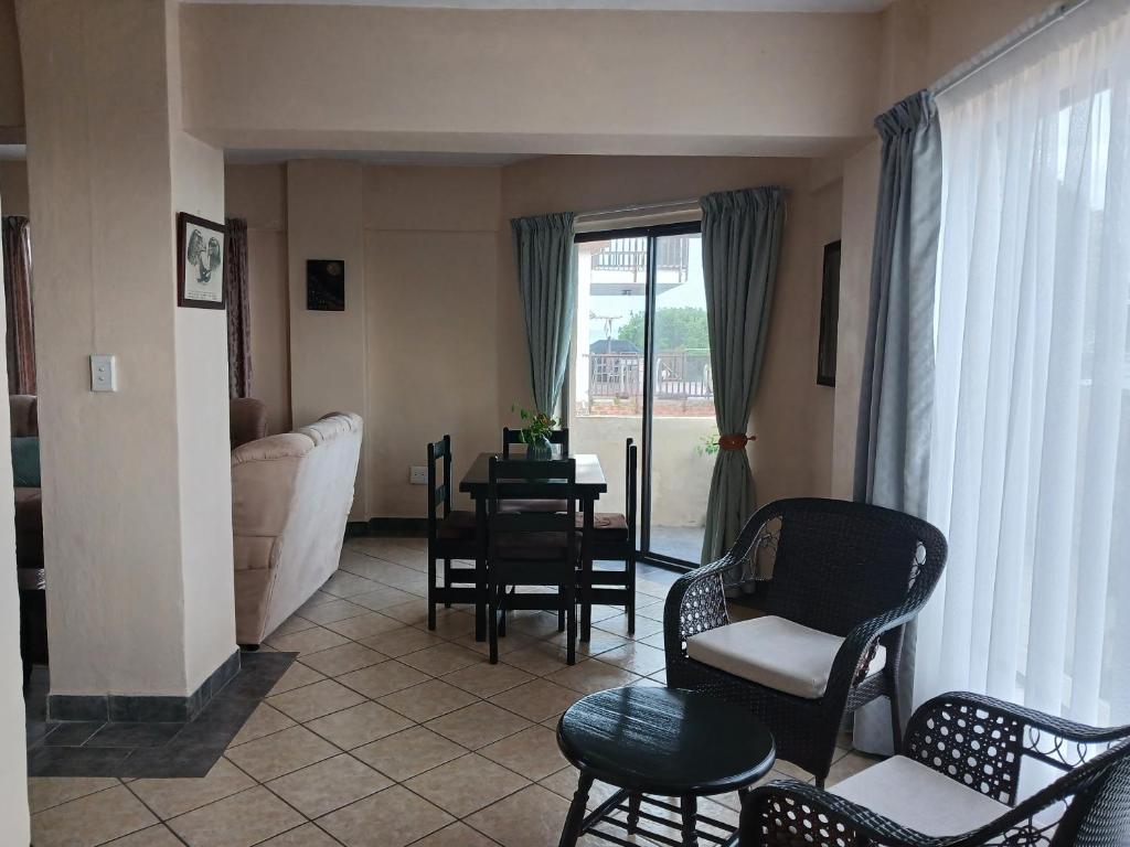 a living room with a couch and a table and chairs at Kaaimans Crest Sea-View Apartments - Great Brak River in Groot Brak Rivier