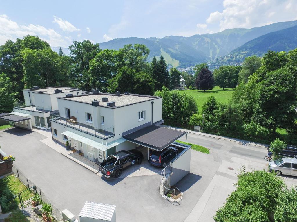 eine Luftaufnahme eines weißen Hauses mit darin geparkten Autos in der Unterkunft Penthouse Waterside by All in One Apartments in Zell am See