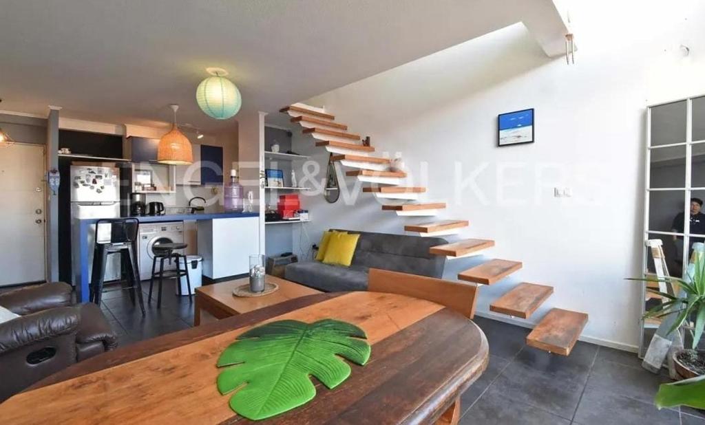 een woonkamer met een houten tafel en een trap bij Live a Beach Life in the Heart of La Serena! in La Serena