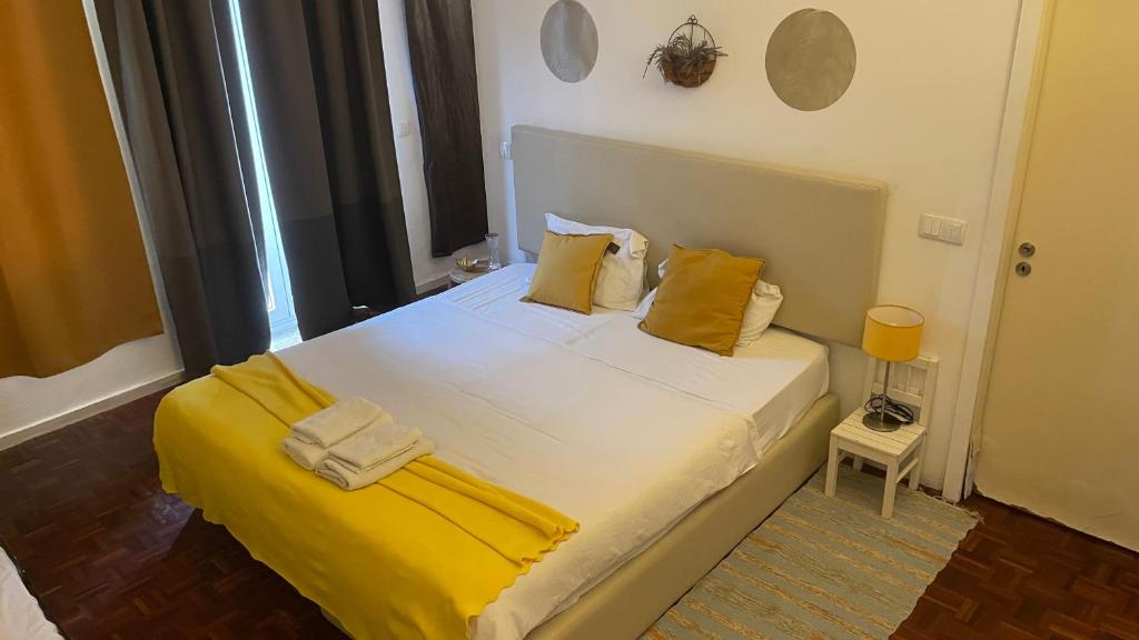 a bedroom with a large bed with yellow pillows at Pink Yellow Porto Apart in Porto