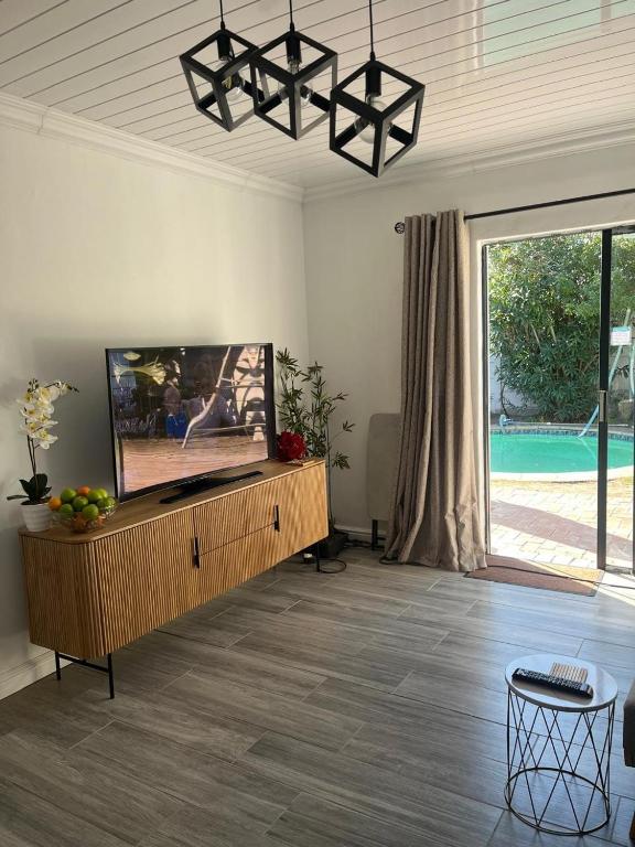 a living room with a flat screen tv on a entertainment center at Balmoral Kids Party Venue in Cape Town