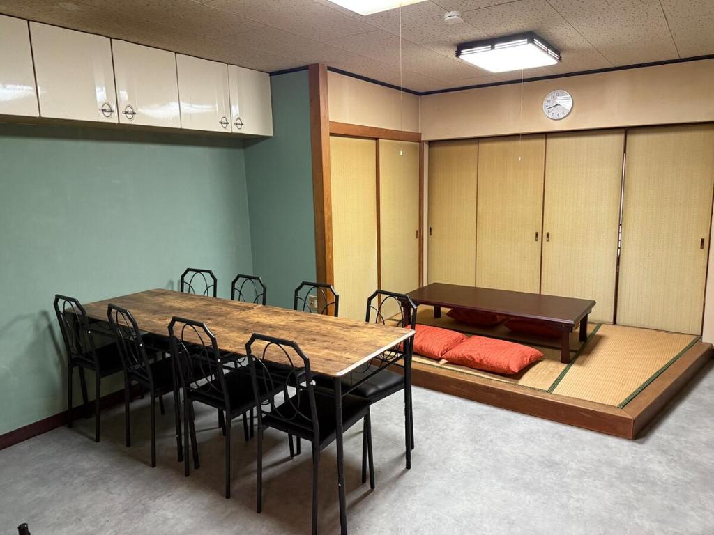 een kamer met een tafel en stoelen en een bed bij 桑名のお宿三栄町 in Kuwana