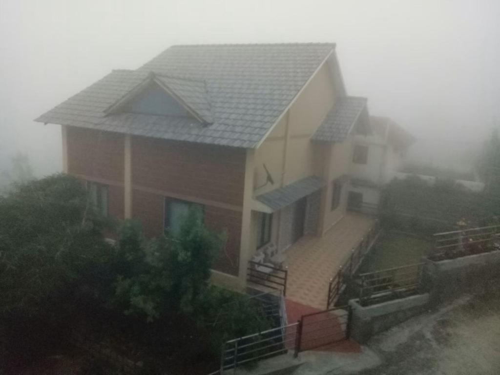 a house in the fog with a house at Pleasant Stay Coonoor-A Serene Hillside Retreat in Coonoor