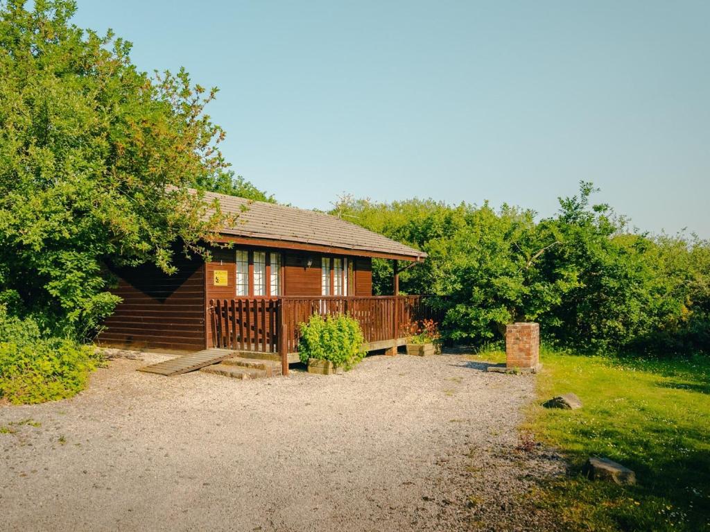 a log cabin with a porch and a fence at 1 Bed in Clovelly 00355 in Clovelly