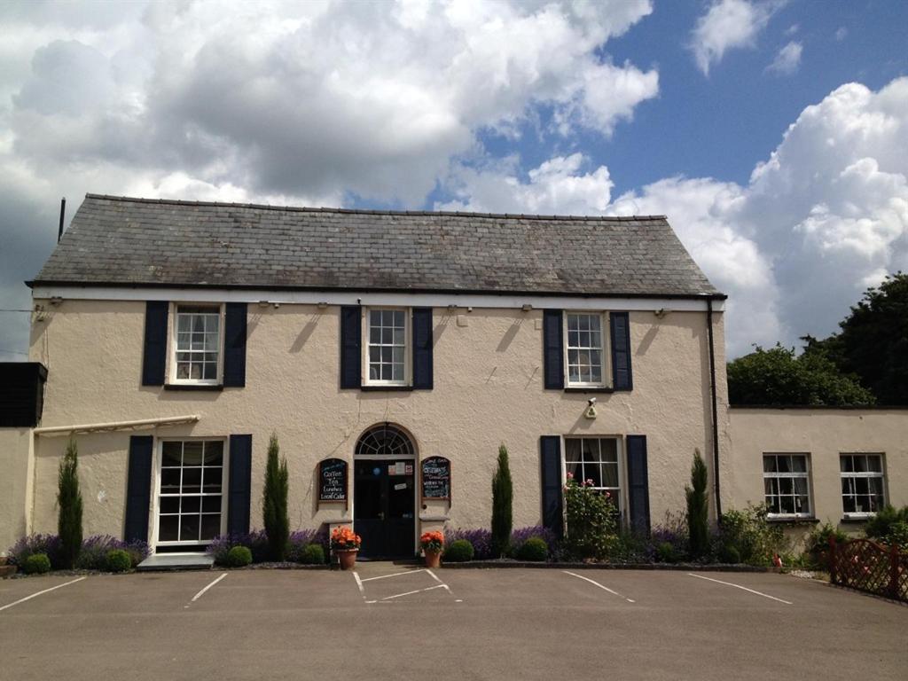 a building with a parking lot in front of it at Castle Lodge Wilton in Ross on Wye