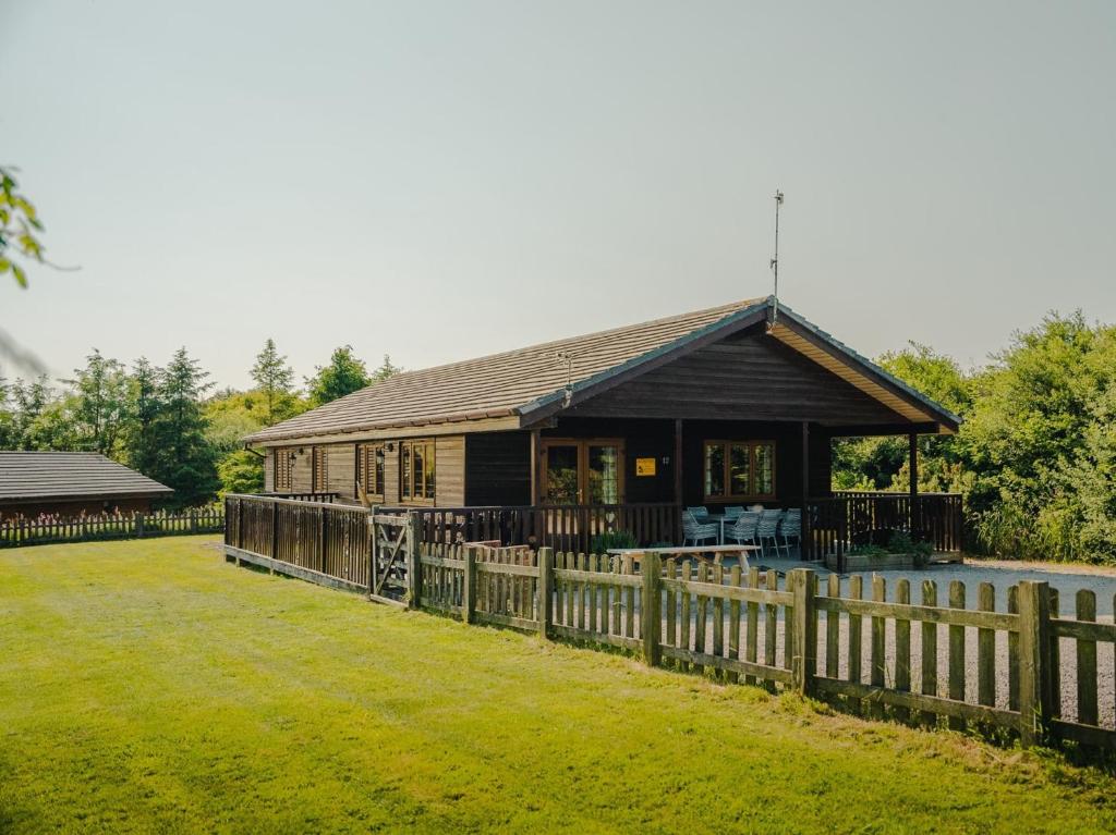a wooden house with a fence in front of it at 4 Bed in Clovelly 00356 in Clovelly