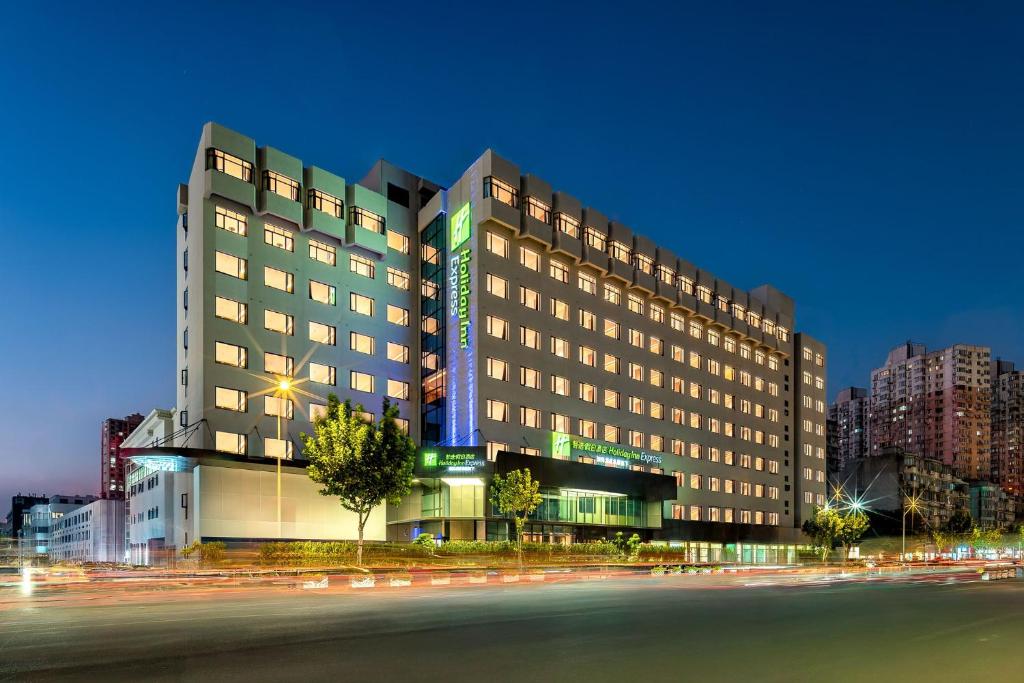 a large hotel building with a street in front of it at Holiday Inn Express Shanghai Changyang Road by IHG in Shanghai