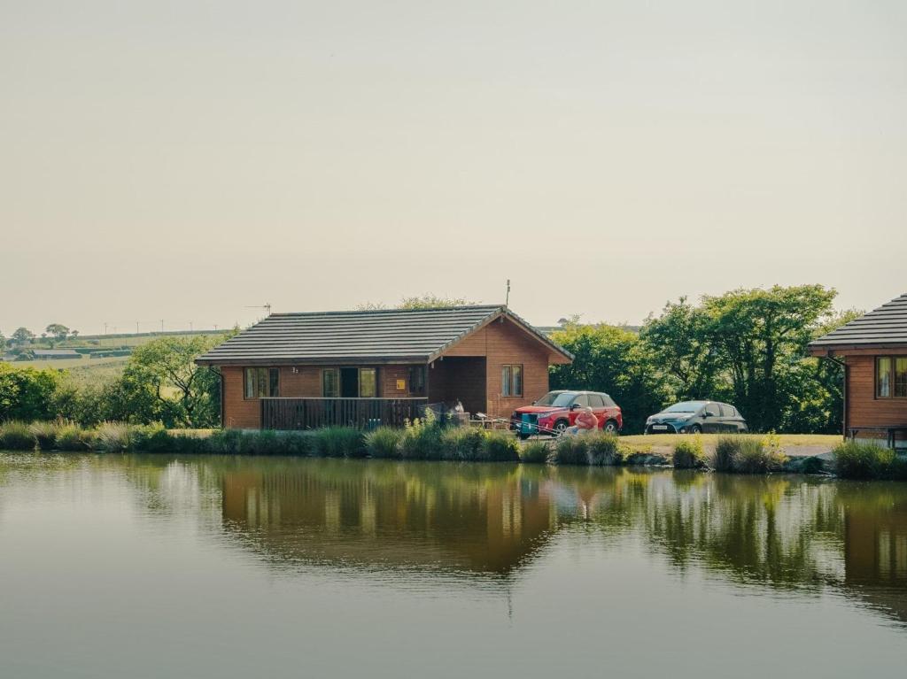 a house with two cars parked next to a lake at 2 Bed in Clovelly 00361 in Clovelly