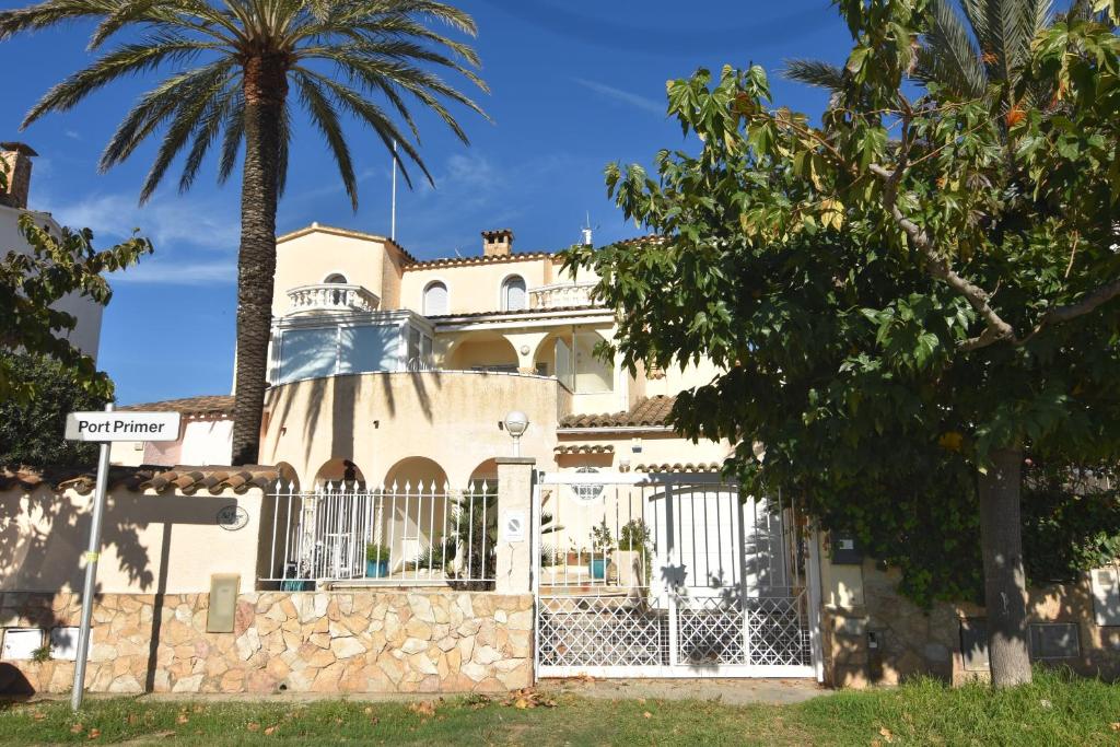 a house with a gate and a palm tree at RNET - Port Primer Empuriabrava in Empuriabrava