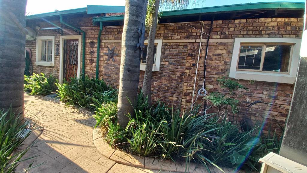 a brick house with a palm tree in front of it at Granny at Umgeni in Pretoria