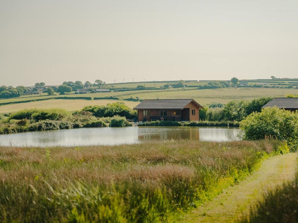 a house in the middle of a field next to a lake at 2 Bed in Clovelly 00362 in Clovelly