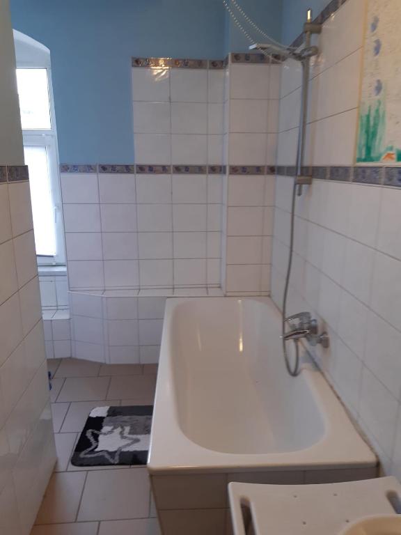 a white bathroom with a tub and a sink at Ferienwohnung Petersbrunnen in Zaschwitz