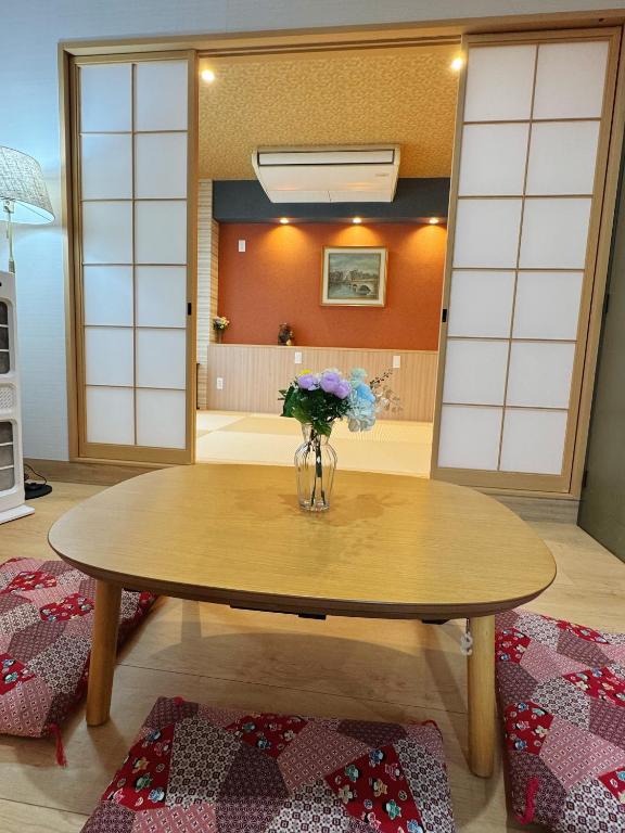 a table with a vase of flowers on top of it at OmOTeNaShI YAHIRO in Tokyo