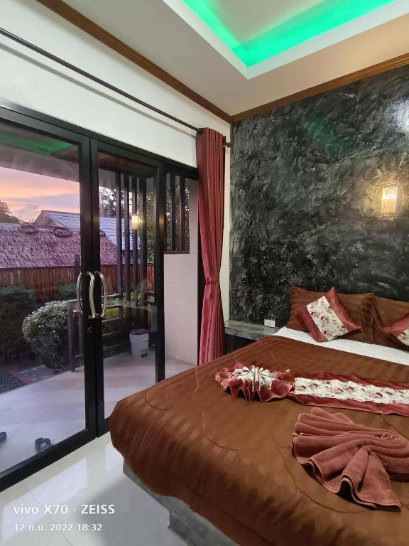 a bedroom with a large bed and a large window at Laila Places at Lanta in Ko Lanta