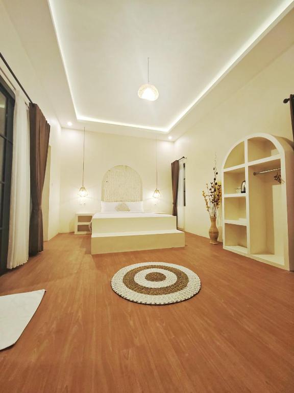 a bedroom with a bed and a rug on a wooden floor at Vikosa Villa Private Pool With View in Yogyakarta