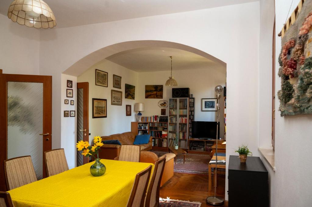 a dining room and living room with a yellow table at Villa d'Este - Historic City Villa with WiFi & Air Conditioning in Ferrara