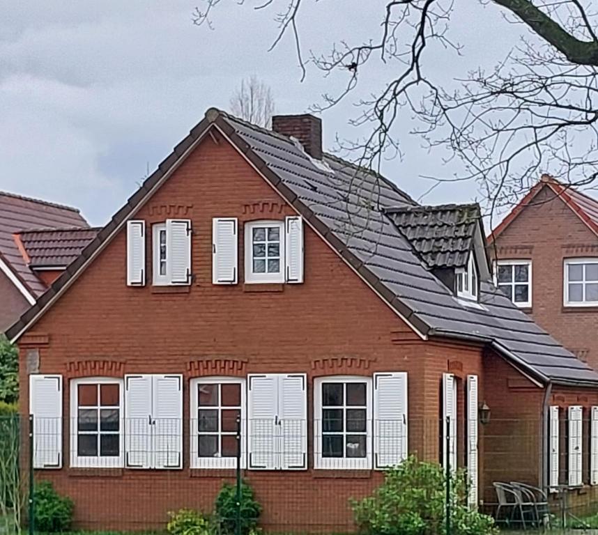 a red house with white windows and a roof at Haus am Ponyhof in Aurich