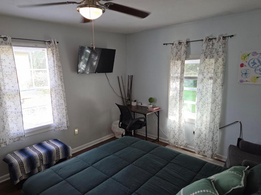 a bedroom with a blue bed and a ceiling fan at Mellow Yellow in Jackson