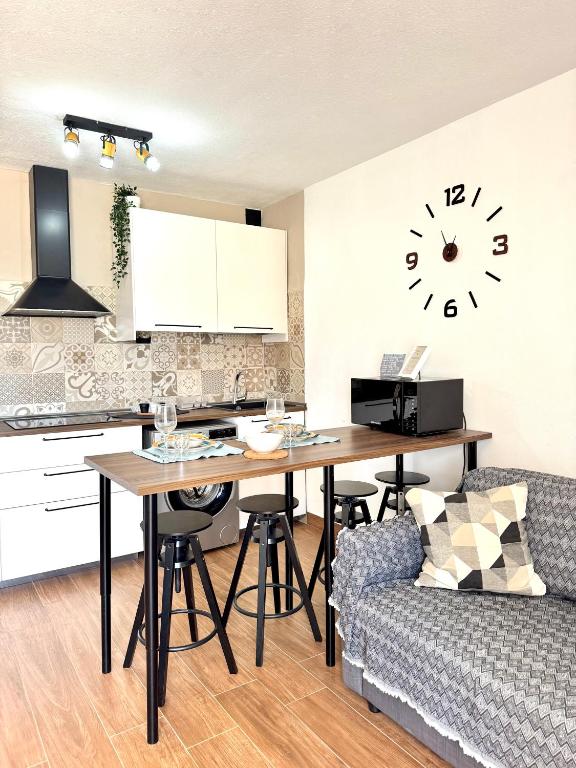 a kitchen with a table and a couch and a clock at Casa Morena in Costa de Antigua