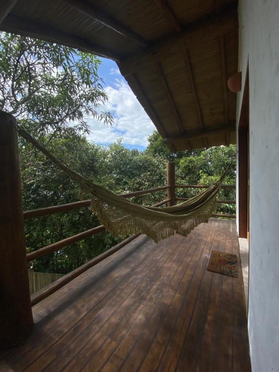 a hammock on the porch of a house at Pousada Porto Caraíva in Caraíva
