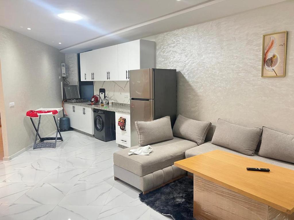 a living room with a couch and a kitchen at Real appartement in El Jadida