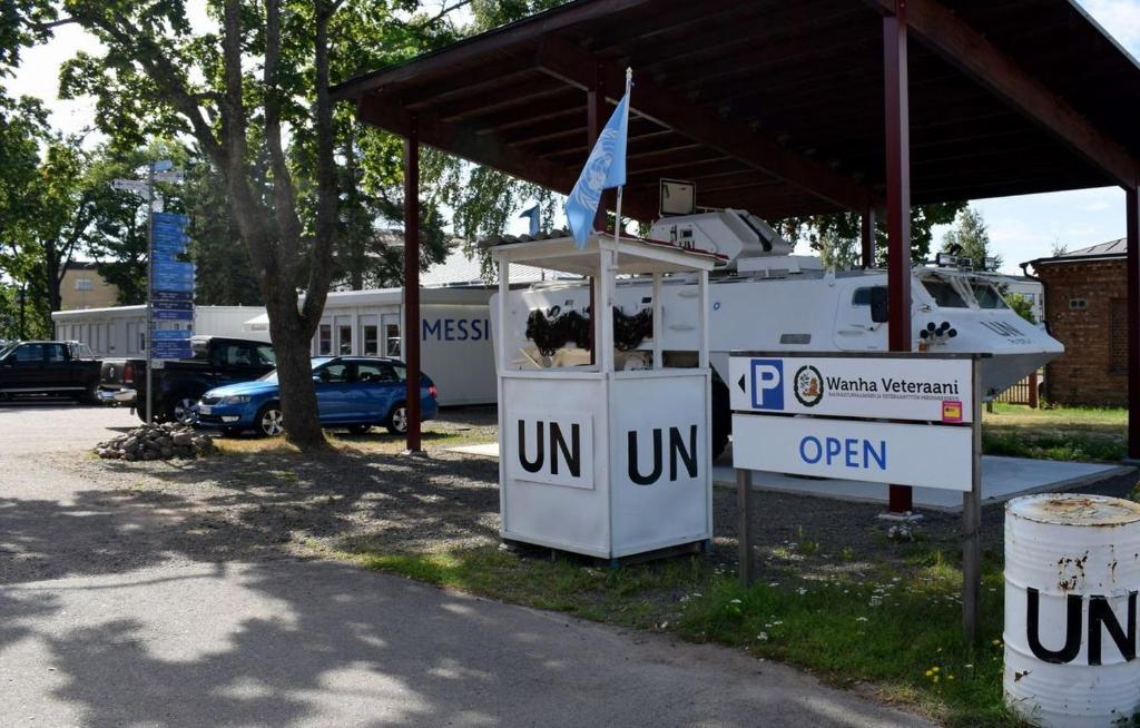 una gasolinera con un cartel de abierto en un estacionamiento en Camp Hamina, en Hamina