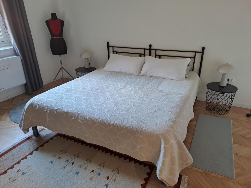 een slaapkamer met een groot bed met een blauw dekbed bij Serenissima Retro Apartment in Muggia