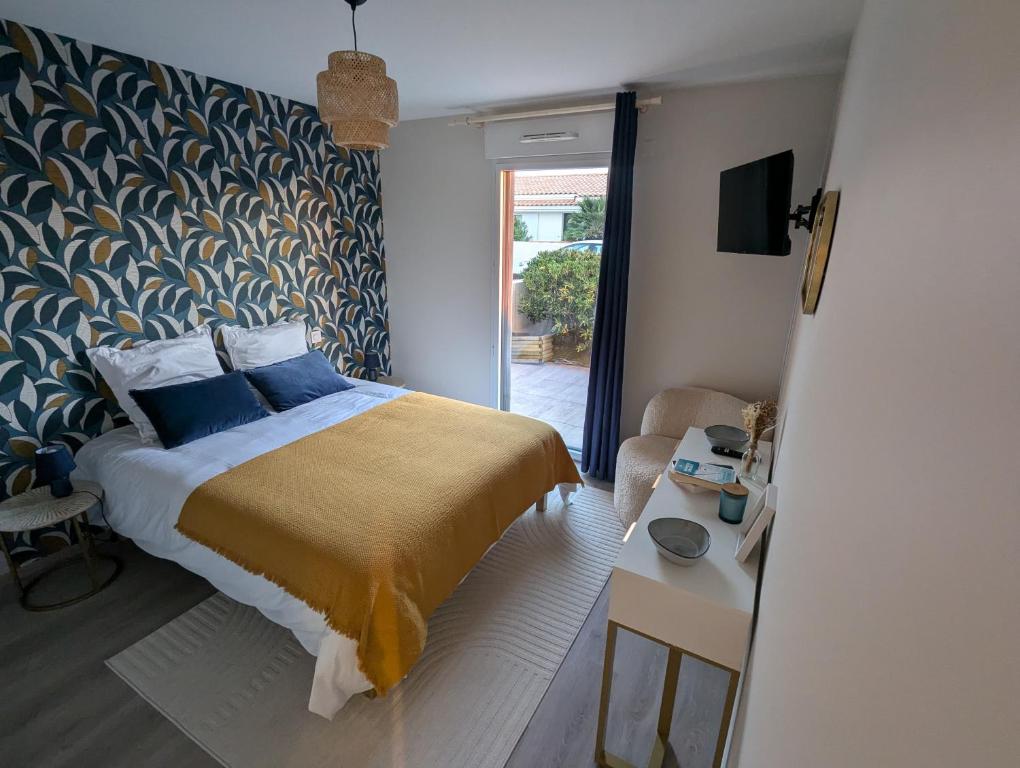 a bedroom with a bed with a blue and gold blanket at Côté Phares, 4 étoiles, appartement 43 m2 Vue Mer in Les Sables-dʼOlonne
