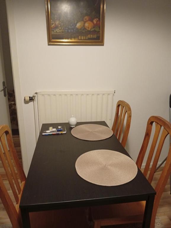 een zwarte eettafel met twee matten erop bij B&Bestrada in Vaggeryd