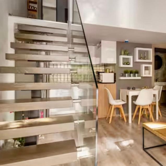 a staircase in a living room with a table and chairs at CITY Loft Lux in Thessaloniki